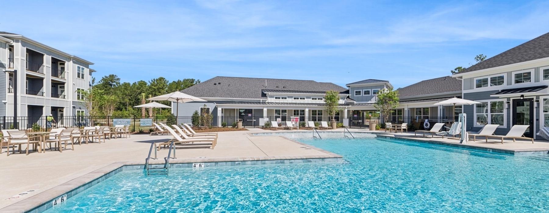 a swimming pool with a deck and chairs by it