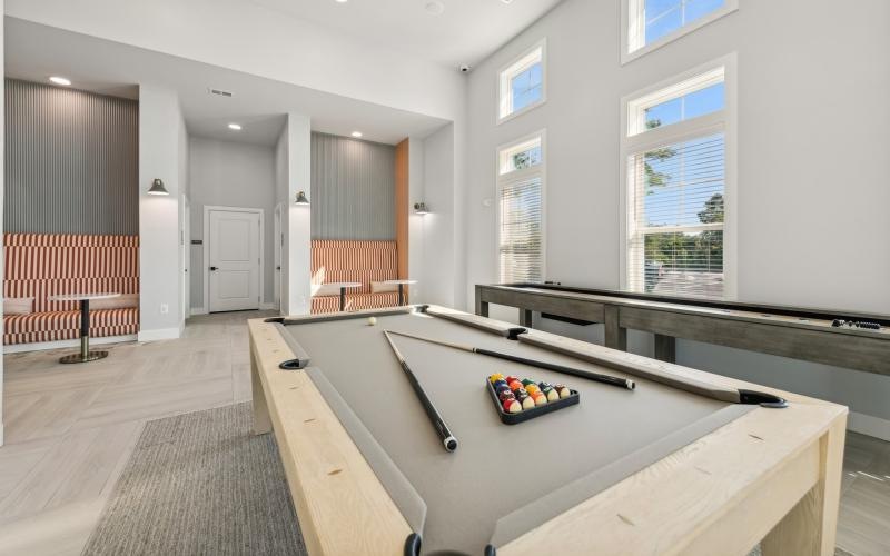 a room with a pool table and a large window